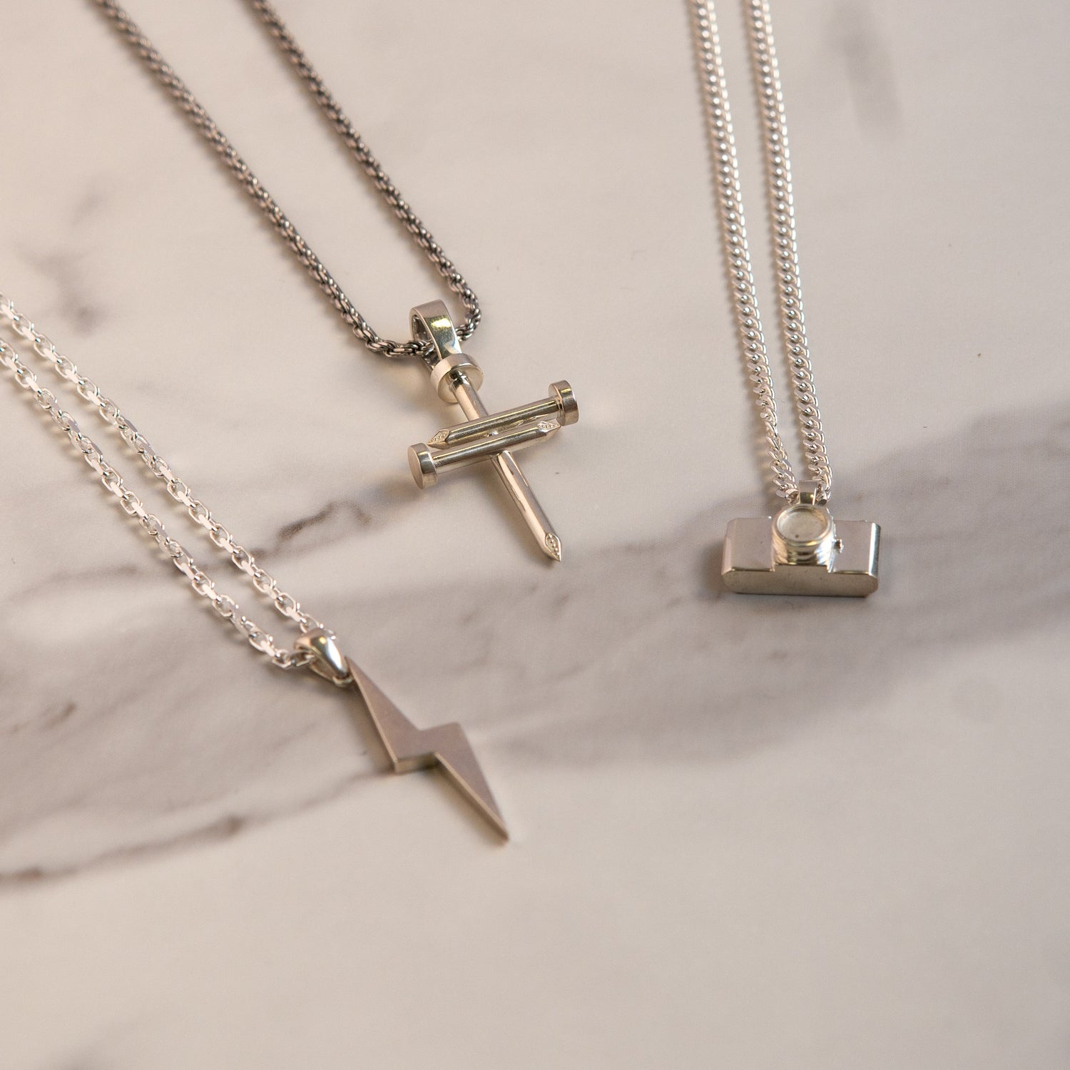 three different pendants next to each other on a marble table